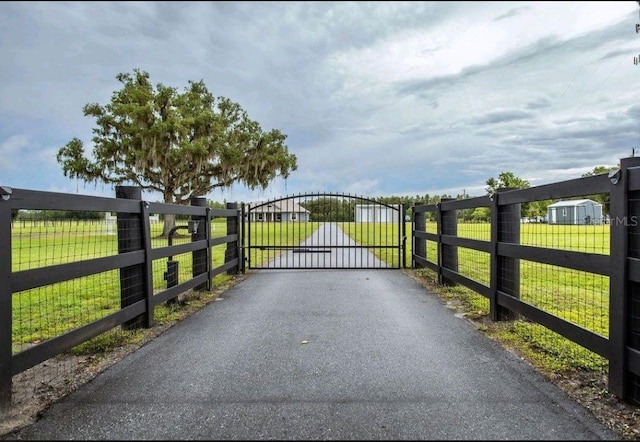 view of gate with a lawn