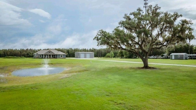 view of home's community featuring an outdoor structure and a lawn