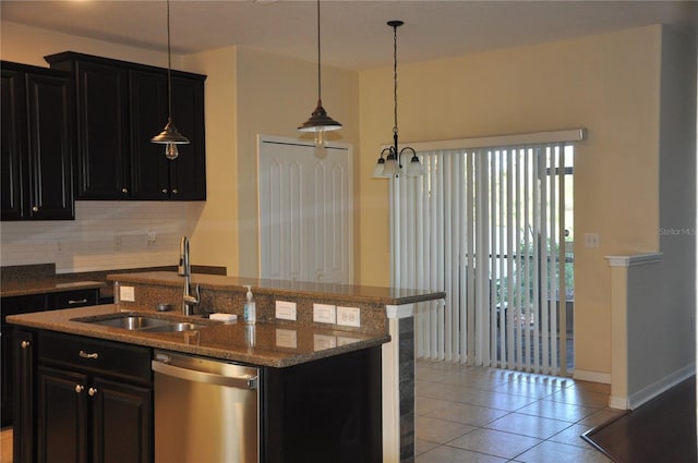 kitchen with stainless steel dishwasher, sink, pendant lighting, an island with sink, and light tile patterned flooring