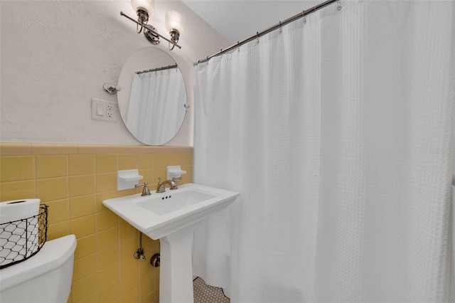 bathroom with tile walls and toilet