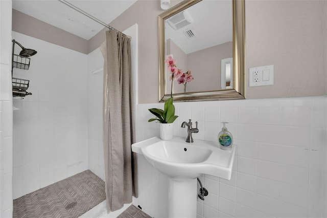 bathroom with a shower with curtain and tile walls