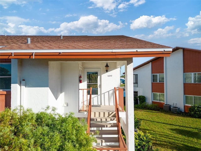 4859 Independence Dr, Bradenton, FL 34210 - property entrance featuring a yard, a shingled roof, and stucco siding