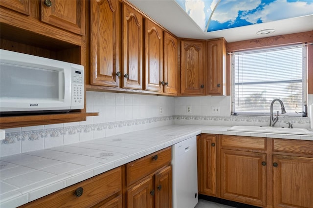 4859 Independence Dr, Bradenton, FL 34210 - kitchen with a sink, white appliances, brown cabinets, and backsplash