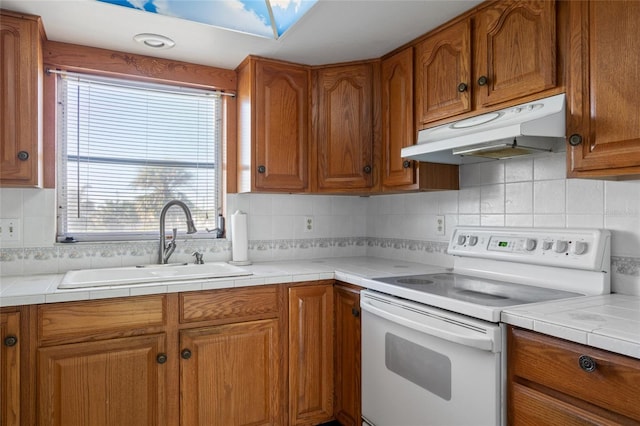 4859 Independence Dr, Bradenton, FL 34210 - kitchen featuring white electric range oven, under cabinet range hood, a sink, and brown cabinets