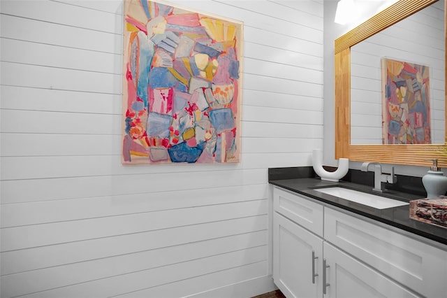 bathroom featuring wood walls and vanity