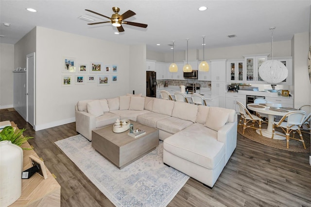 living room featuring ceiling fan and dark hardwood / wood-style flooring