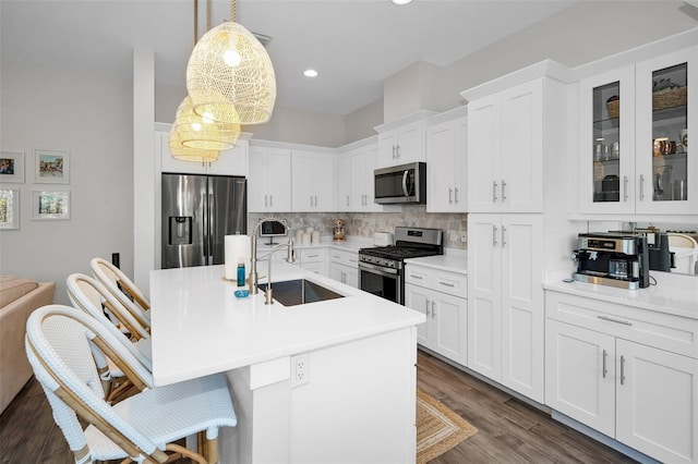 kitchen with sink, hanging light fixtures, dark hardwood / wood-style floors, appliances with stainless steel finishes, and white cabinetry