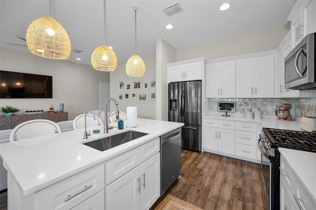 kitchen featuring a center island with sink, white cabinets, sink, and appliances with stainless steel finishes