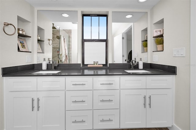 bathroom featuring built in features, vanity, and an enclosed shower