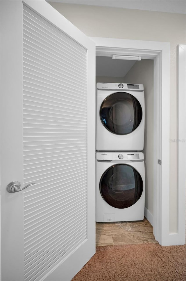 laundry area featuring light colored carpet and stacked washing maching and dryer