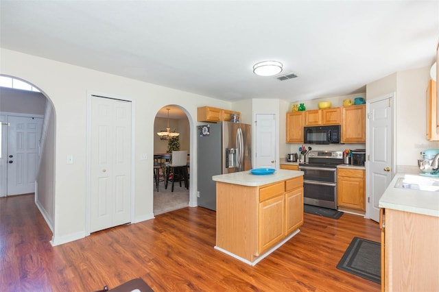 kitchen with sink, a kitchen island, dark hardwood / wood-style floors, and appliances with stainless steel finishes