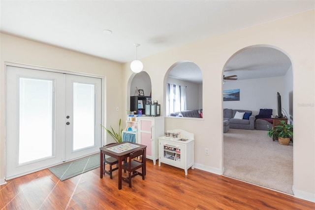 foyer featuring ceiling fan, french doors, wood-type flooring, and plenty of natural light