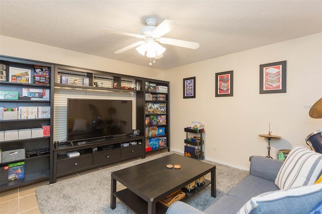 living room featuring ceiling fan, light tile patterned flooring, and a textured ceiling