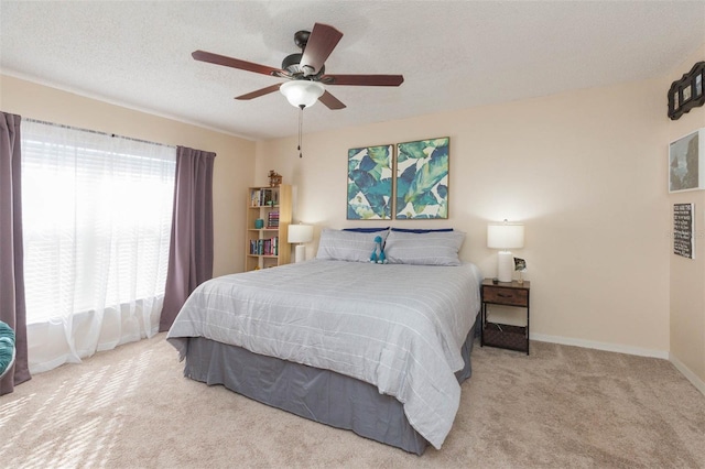 bedroom with carpet, a textured ceiling, and ceiling fan