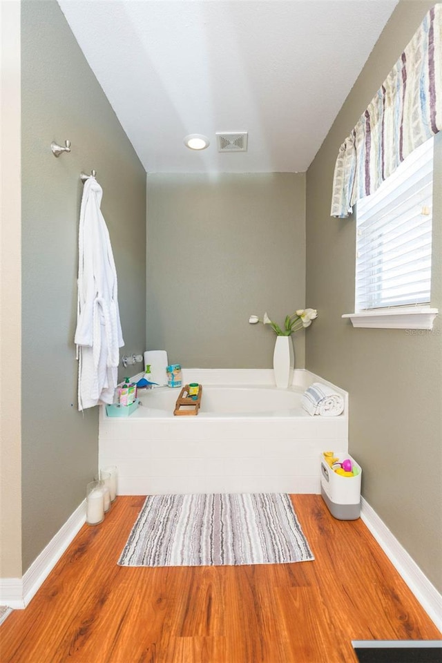 bathroom with hardwood / wood-style floors and a bathtub