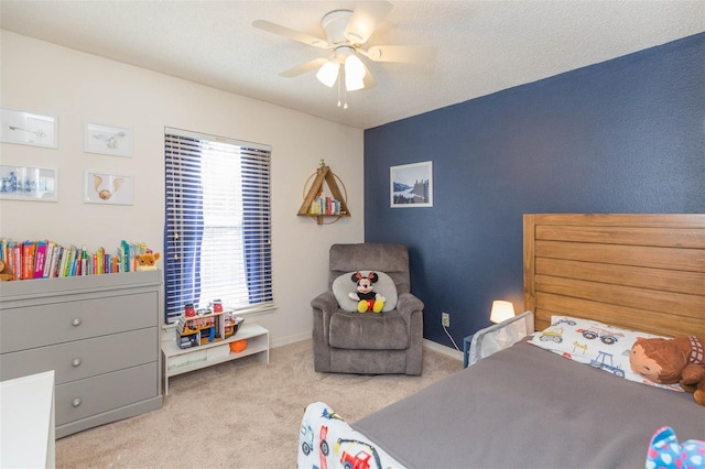 bedroom featuring ceiling fan, light colored carpet, and a textured ceiling