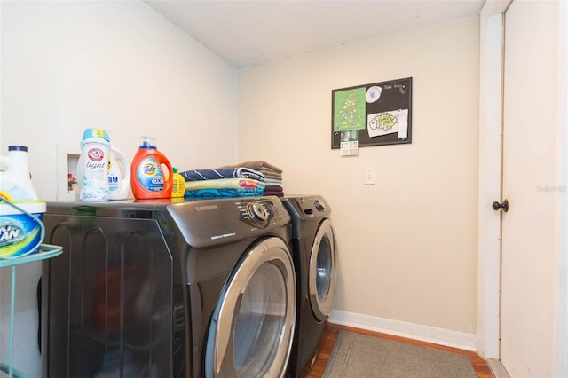 washroom with hardwood / wood-style floors and washer and dryer