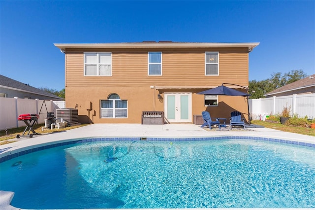 back of house with a fenced in pool, french doors, and central AC unit