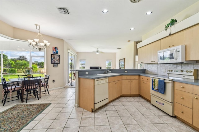 kitchen with decorative backsplash, kitchen peninsula, ceiling fan with notable chandelier, white appliances, and light tile patterned floors