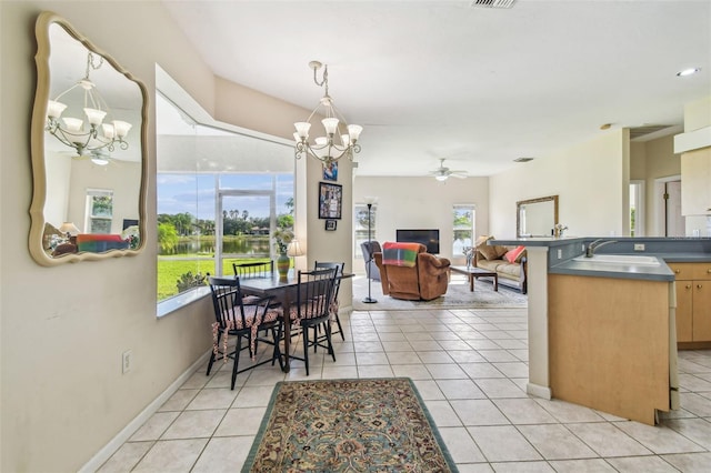 dining room featuring sink, light tile patterned floors, and ceiling fan with notable chandelier