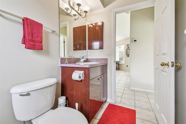 bathroom with tile patterned floors, vanity, toilet, and a chandelier