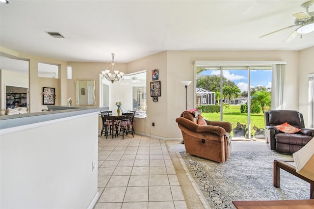 living room featuring ceiling fan with notable chandelier and light tile patterned flooring