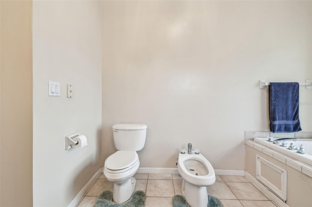 bathroom with tile patterned flooring, toilet, and a bidet