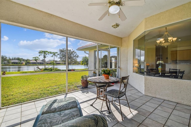 sunroom / solarium featuring ceiling fan with notable chandelier and a water view