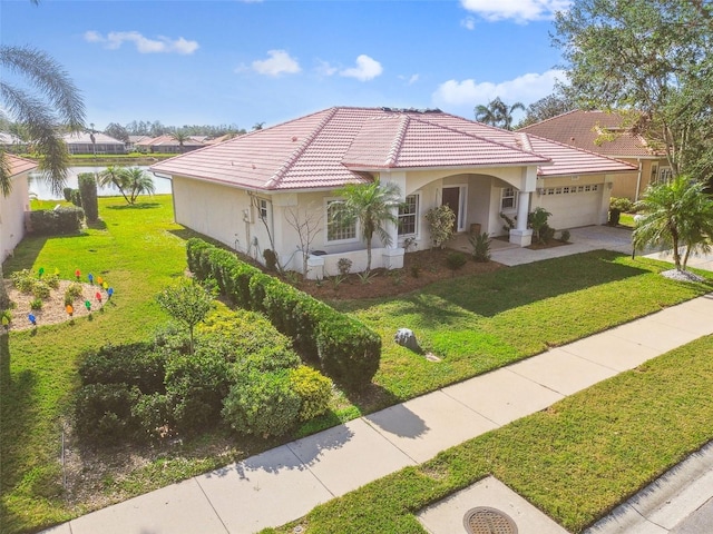 mediterranean / spanish-style home with a garage, a water view, and a front yard