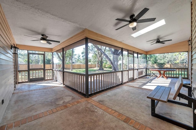 sunroom / solarium featuring ceiling fan and vaulted ceiling with skylight