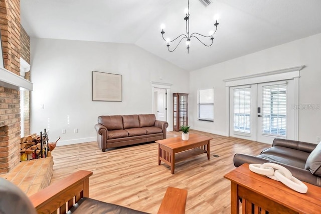 living room featuring french doors, a brick fireplace, light hardwood / wood-style flooring, a chandelier, and lofted ceiling