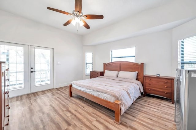 bedroom featuring ceiling fan, light hardwood / wood-style floors, french doors, and multiple windows