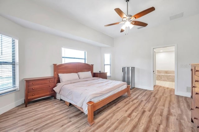 bedroom featuring ceiling fan, connected bathroom, and light hardwood / wood-style flooring