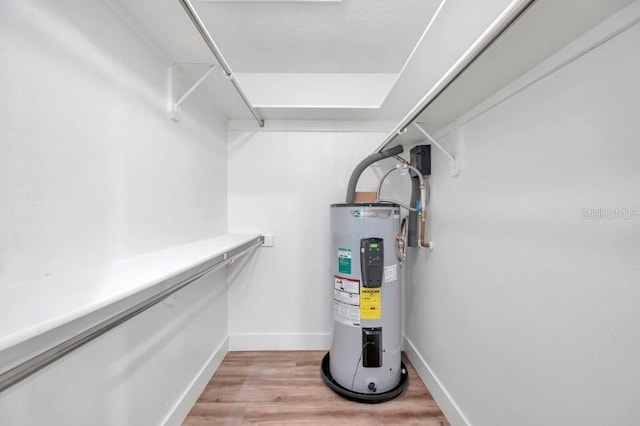 spacious closet featuring light hardwood / wood-style flooring and water heater