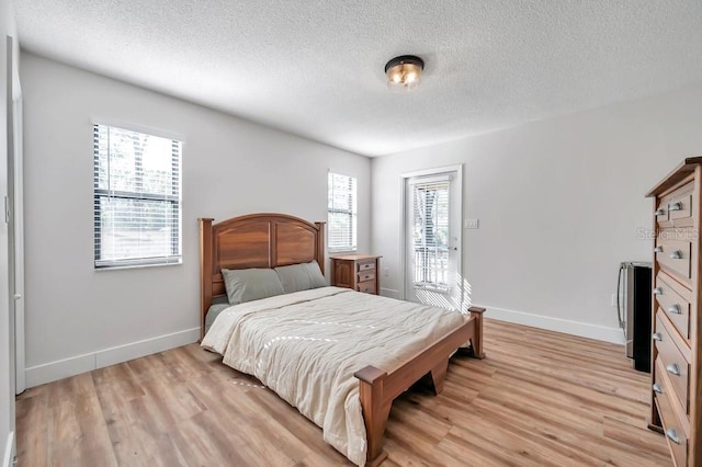 bedroom featuring light wood-type flooring and a textured ceiling