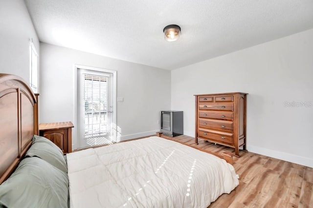 bedroom with a textured ceiling and light wood-type flooring