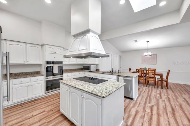 kitchen featuring stainless steel appliances, sink, decorative light fixtures, white cabinets, and a kitchen island