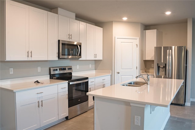 kitchen featuring white cabinetry, sink, a kitchen island with sink, light tile patterned flooring, and appliances with stainless steel finishes