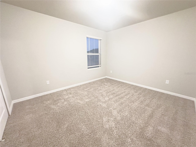 carpeted spare room with baseboards