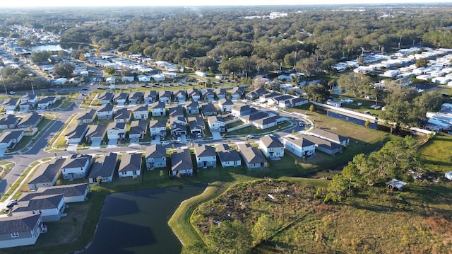 drone / aerial view with a residential view, a forest view, and a water view
