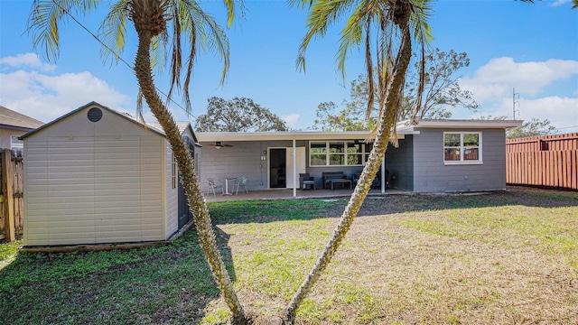 back of property featuring a storage unit, a patio area, and a yard