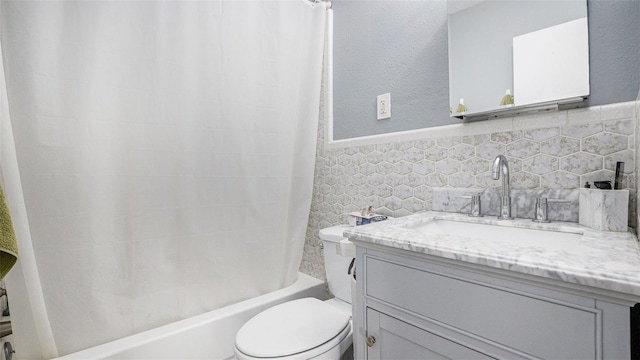 full bathroom with toilet, vanity, shower / bathtub combination with curtain, and tile walls