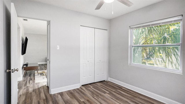 unfurnished bedroom with a closet, ceiling fan, and dark hardwood / wood-style floors