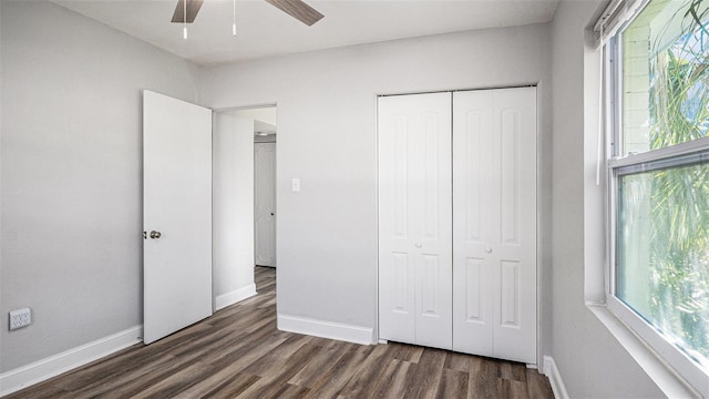 unfurnished bedroom with ceiling fan, a closet, and dark hardwood / wood-style flooring