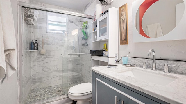 bathroom featuring toilet, vanity, and an enclosed shower