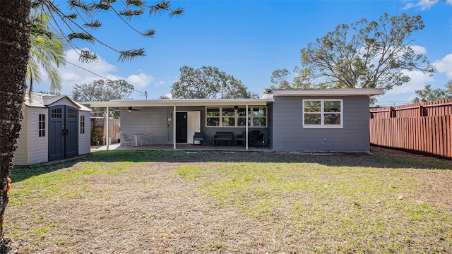 rear view of property with a patio area, a shed, and a lawn