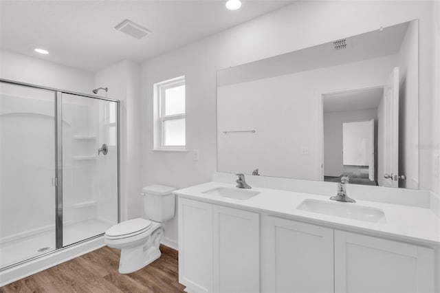 bathroom featuring vanity, wood-type flooring, an enclosed shower, and toilet