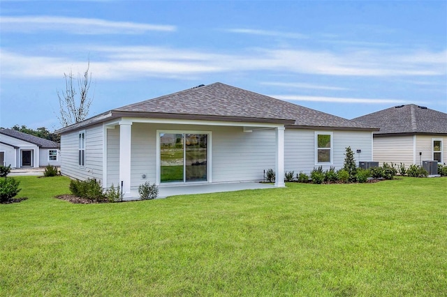 rear view of property with central AC unit, a patio area, and a yard