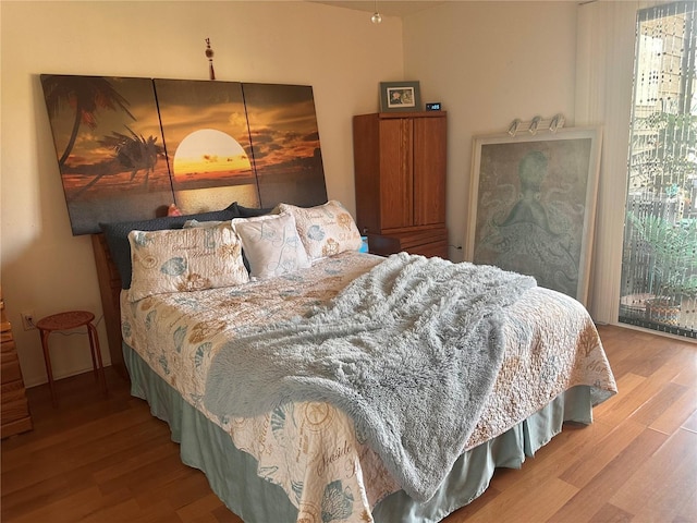 bedroom with multiple windows and wood finished floors