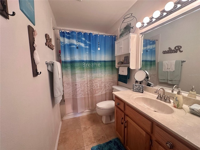 bathroom with baseboards, toilet, vanity, and tile patterned flooring